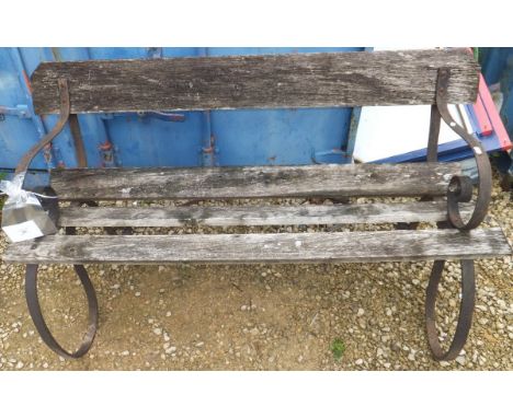 A wooden slatted garden bench with iron scrolled ends