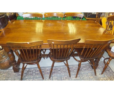 A modern oak refectory style dining table, and a set of eight stick back kitchen chairs with crinoline stretchers (two plus s