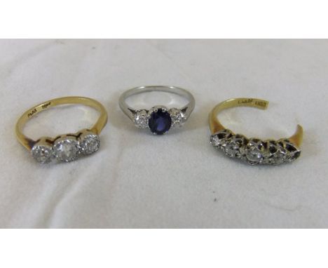 An 18ct gold and platinum ring set with three white stones, a white metal ring set with blue and white stones, and a 18ct gol