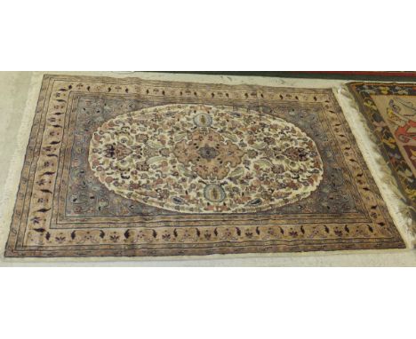 A Persian style rug, the central floral decorated salmon medallion on a cream floral decorated ground within salmon, blue and