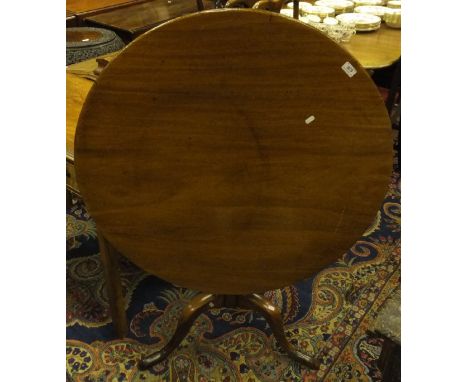 A mahogany tea table, the circular snap top on a baluster turned pedestal to tripod base and pad feet