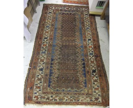 A Caucasian rug, the central panel with hook motifs on a green and blue ground, within a red, cream and blue hook and floral 