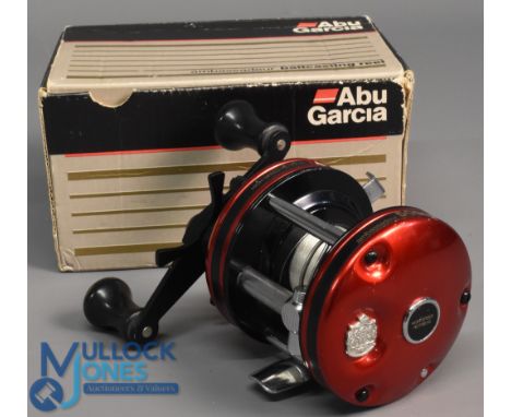 ABU Ambassadeur 5000 multiplier reel foot stamped 84-287-86, star drag level wind, in red, c/w papers in maker's card box