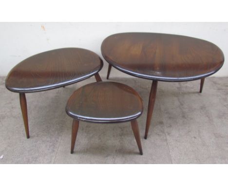 An Ercol pebble nest of three dark elm and beech tables