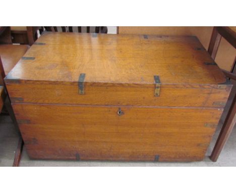 An oak trunk of rectangular form with brass bindings and corners