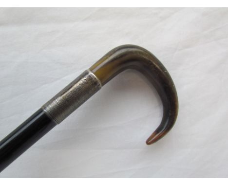 An ebonised walking stick with a silver collar and horn handle