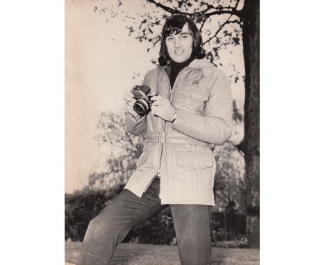 GEORGE BEST   Two photographs of George in civilian clothes, one shows him holding a camera, probably early 70s, PA picture, 