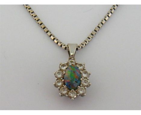 A black opal and diamond pendant, the oval cabochon opal 7.6mm long, in a surround of brilliants, to a white gold box link ch