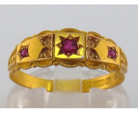 An Edwardian 15 carat gold and ruby ring, gypsy set with three round cut stones, the shank hallmarked Birmingham 1906, finger