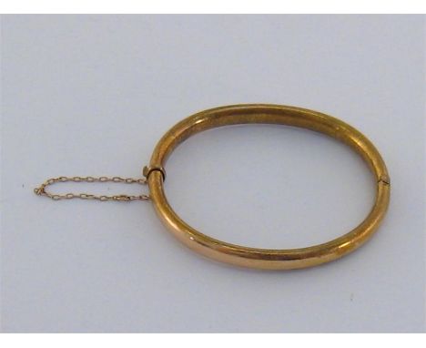 A 15 carat gold hinged bangle, of hollow section, to concealed box link clasp, the tongue stamped ‘15c’, internal diameter 56