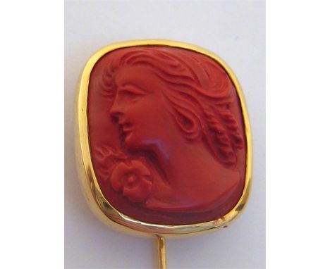 A yellow metal (tests 14 carat) and reconstituted coral cameo stick pin, the cameo depicting a woman in profile, 7cm long, 5.