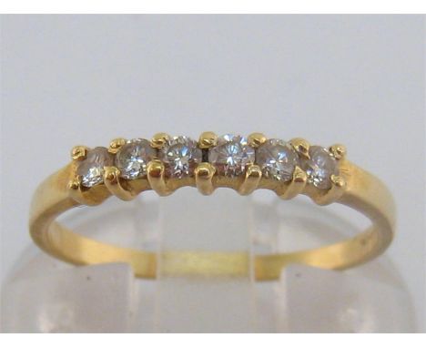A six stone diamond ring, the six brilliants totalling approx. 0.18 carat, the yellow shank stamped ‘14k’, finger size J/K, 1