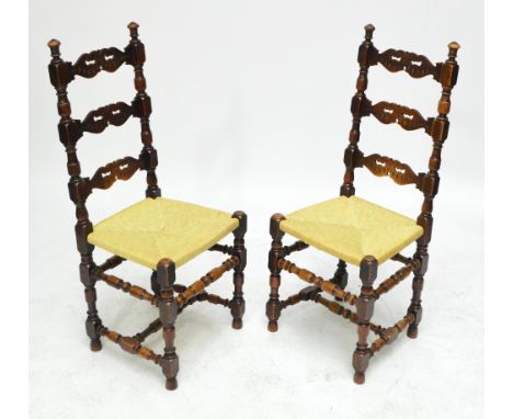 A set of six 1920s oak and stained beech ladder back chairs with pierced bar, ring turned and block uprights, rush seats and 