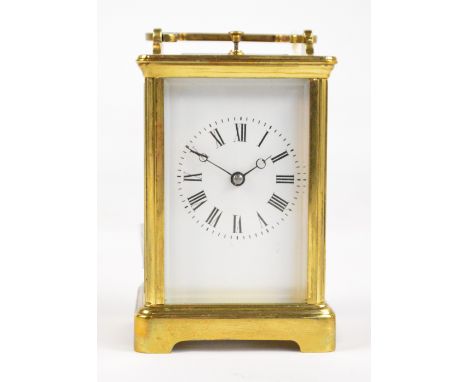 A late 19th century French brass cased repeating carriage clock with swing loop handle above rectangular white enamel dial se