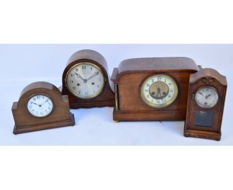 A collection of four early 20th century mantel clocks including an oak example with shaped top, the cream enamel chapter ring