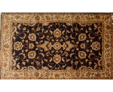 A Ziegler carpet decorated with floral and foliate sprays on a dark blue ground within similarly decorated beige border, 230 