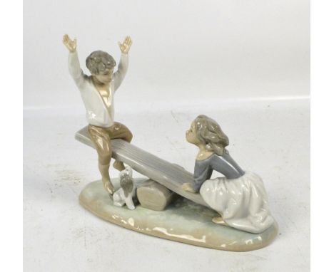 A Lladro figure group modelled as two children playing on a seesaw, width 22cm.
