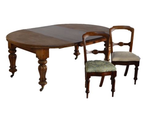 A Victorian mahogany circular extending dining table with twin broad leaves and lobed legs to castors and a set of ten Victor