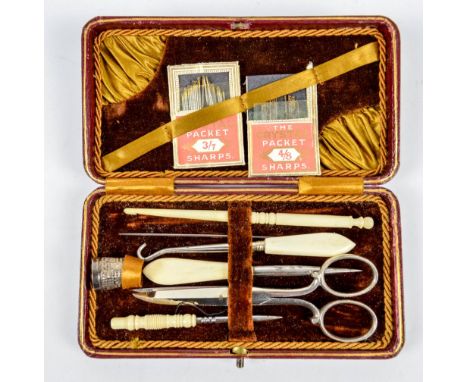 An Edwardian Moroccan leather cased sewing kit with bone handled implements and a hallmarked silver thimble, size 14, Chester