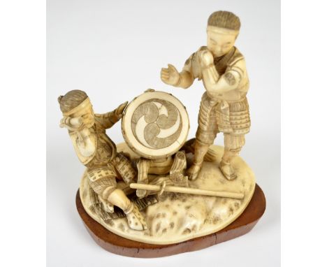 Japanese Meiji period carved ivory sectional okimono figure group of a man playing a drum and a further musician with incised