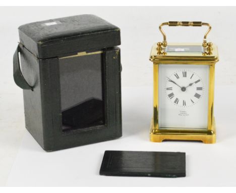 An early 20th century French brass cased carriage clock with swing loop handle above rectangular white enamel dial set with R