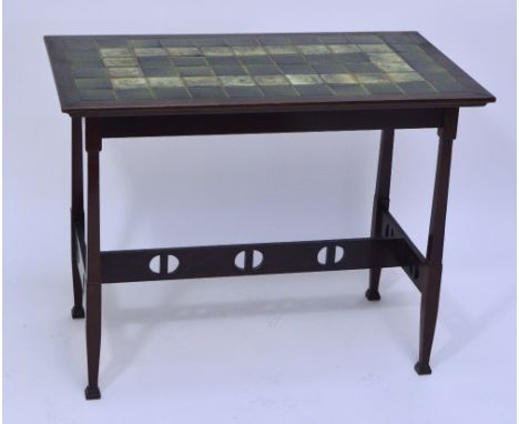 An Arts and Crafts mahogany and green tile topped table above stylised and pierced stretchers, length 92cm and width 54cm. CO