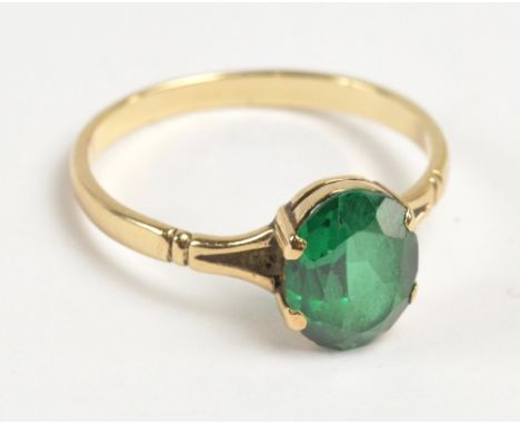 A yellow metal ring set with oval cut green spinel in claw setting, size T 1/2, 2.5g