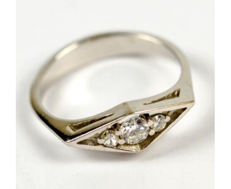 A white metal and diamond dress ring, the central round brilliant cut stone flanked by two smaller non precious clear round s