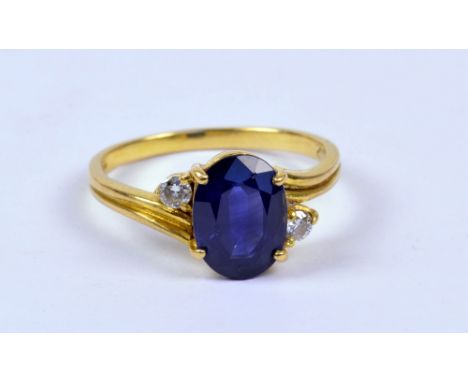An 18ct yellow gold ring set with oval cut sapphire flanked by two small diamonds, size K/L, approx 3g. CONDITION REPORT: Sma