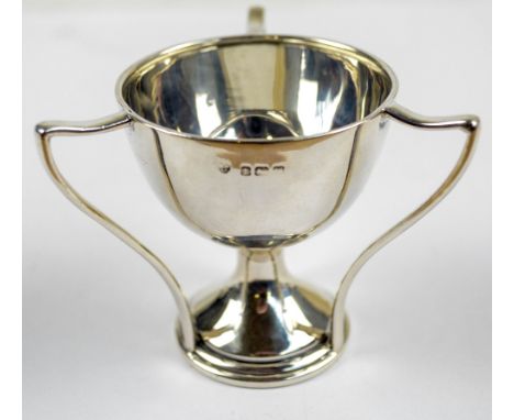 WILLIAMS (BIRMINGHAM) LTD; a George V hallmarked silver miniature tyg trophy with three angled  handles terminating on the ed