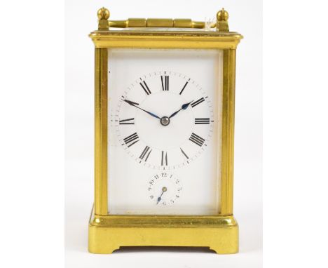 A large late 19th century French brass cased carriage clock with swing loop handle above white enamel dial set with Roman num