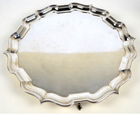 BARKER BROTHERS SILVER LTD; a George VI hallmarked silver salver with pie crust rim and three stepped hoof feet, diameter 32.