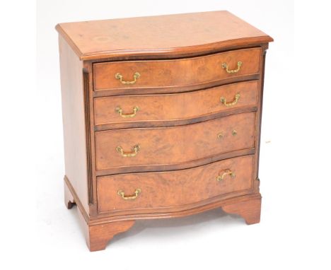 A reproduction burr walnut and cross banded serpentine chest of four long graduated drawers of small proportion raised on bra