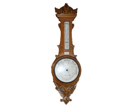 An early 20th century carved oak aneroid barometer, the circular dial inscribed "R. Ramsbottom Manchester" below thermometer,