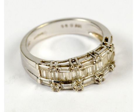 A 18ct white gold melee diamond ring with central channel set graduated baguette stones set between a baguette and round diam