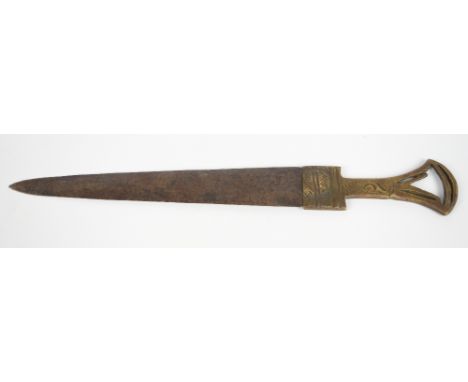 An Eastern brass dagger with incised and pin pricket decorated pierced handle bearing traces of an old repair, length 34cm.