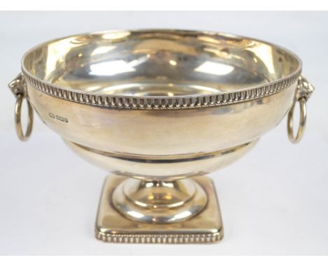 ATKIN BROS; a George V hallmarked silver circular bowl with twin lion mask and ring handles, raised on waisted stem to square