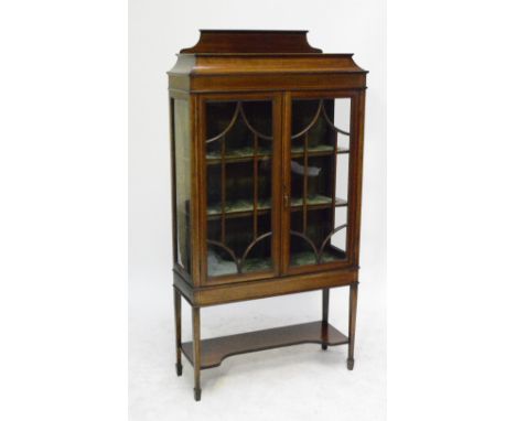 An Edwardian mahogany and satinwood banded display cabinet with raised top, twin glazed door enclosing velvet lined shelves a