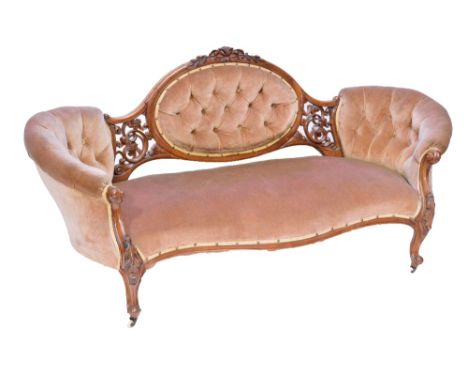 A Victorian walnut framed upholstered sofa with buttoned oval central section flanked by a carved foliate scroll motif, on ca