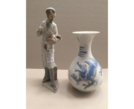 A Lladro figure of a vet holding a dog; together with a Lladro vase