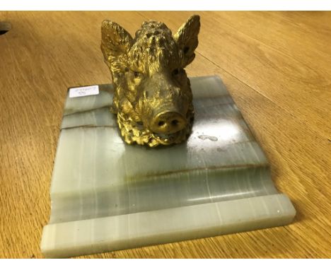 A 19th/20th C gilt boar's head inkwell set with red stones to the eyes on an onyx base