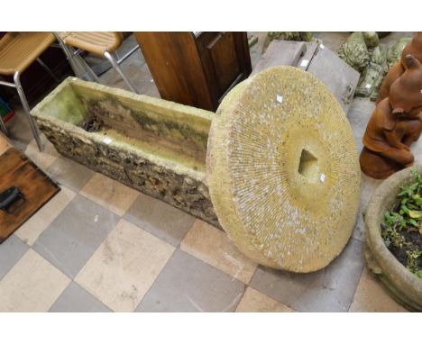 A carved stone garden trough and a mill stone 