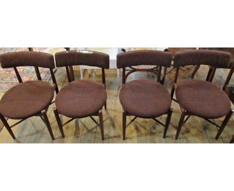 A set of four G-Plan teak framed dining chairs, each with bow rail, circular seat on turned tapering legs, united by a cross 