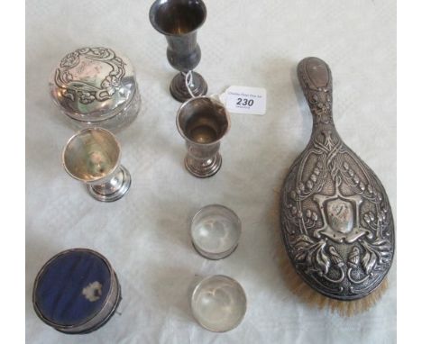 A silver backed brush, a cut glass dressing table pot with silver cover, two silver serviette rings, a silver mounted pin cus