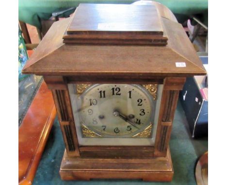 An Edwardian mantle clock, the architectural case enclosing an eight day movement, faced by silvered Arabic dial.