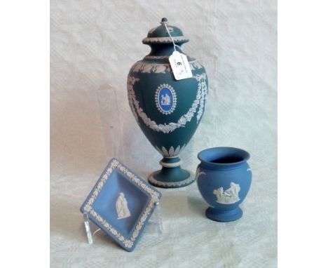 An unmarked Wedgwood-type covered urn, typically decorated in shallow relief with ribbon tied floral swags and repeating leaf