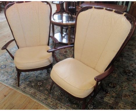 A pair of ercol high back parlour armchairs, each having stick back, out-swept arms on turned tapering legs.