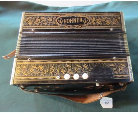 An early/mid-20th century Hohner 14 key accordion in a black lacquered gilt decorated case.