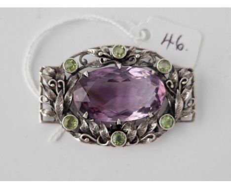 A ARTS AND CRAFTS SILVER SUFFRAGETTE BROOCH SET WITH A CENTRAL AMETHYST AND PERIDOT