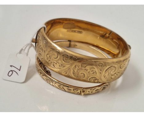 A wide rolled gold bangle and a small example